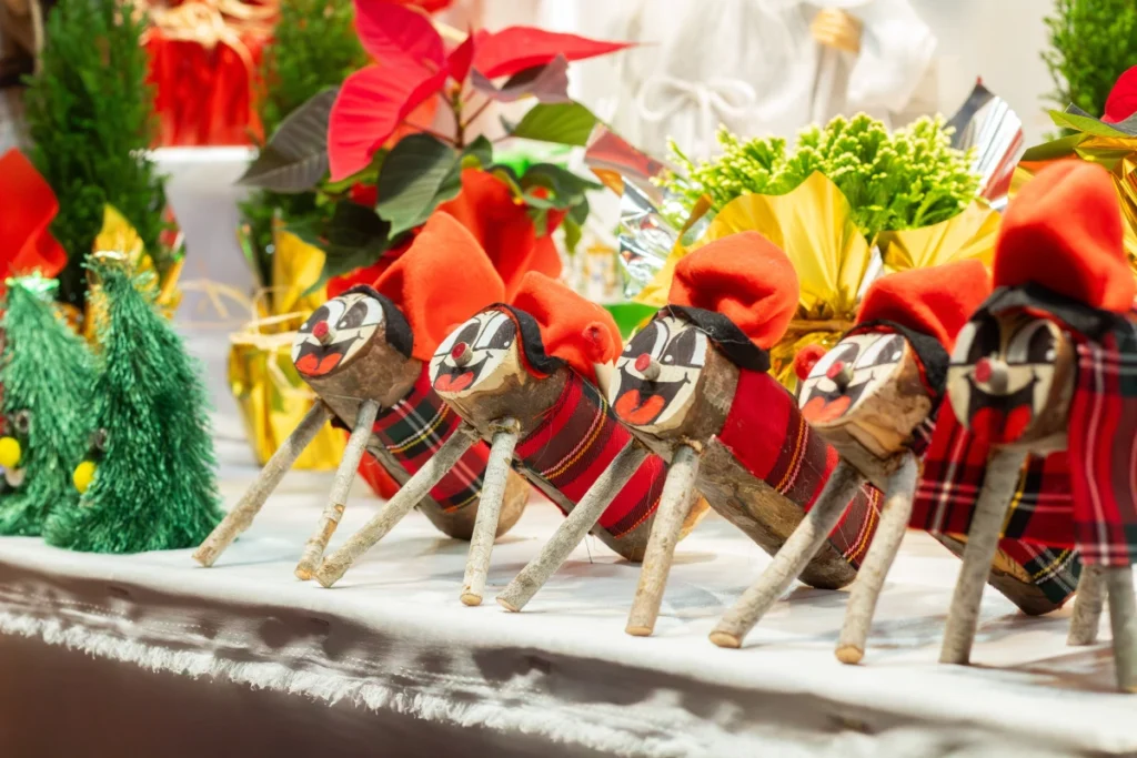 Figuras coloridas del Tió de Nadal con caras sonrientes y sombreros rojos en los mercados de Navidad en Tarragona, decoradas para la temporada de navidad en Tarragona.