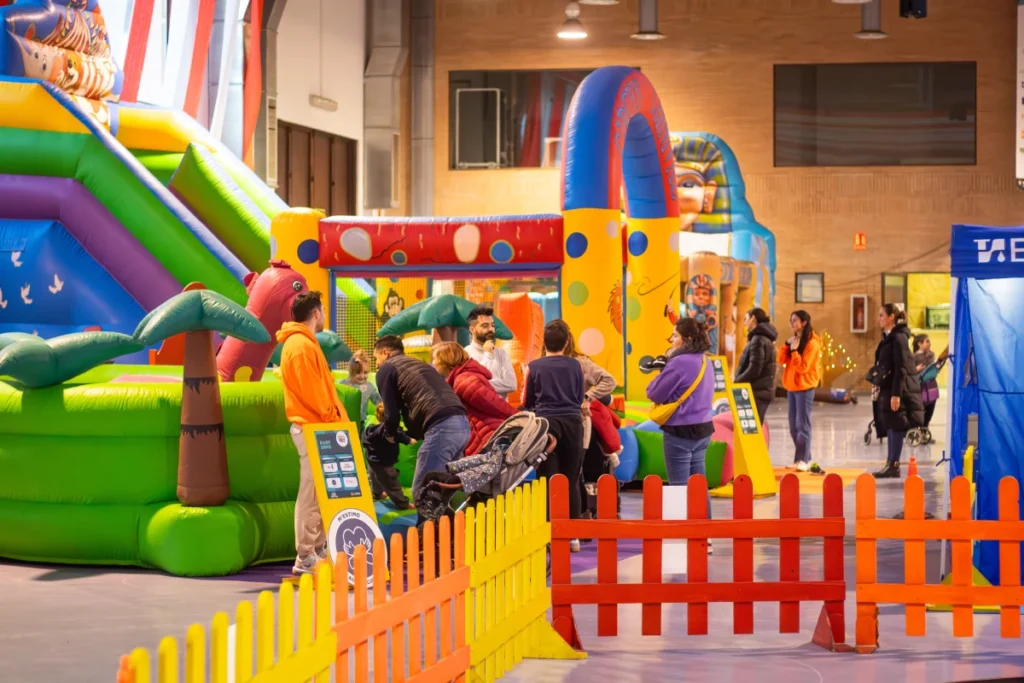 Un área de juegos interior colorida con toboganes inflables y obstáculos, donde los niños se entretienen durante la navidad en Tarragona.